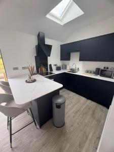 a kitchen with a white counter and blue cabinets at Portbridge Nest in Chew Magna
