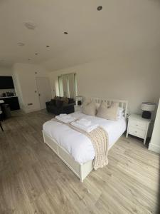 a bedroom with a large white bed and a couch at Portbridge Nest in Chew Magna
