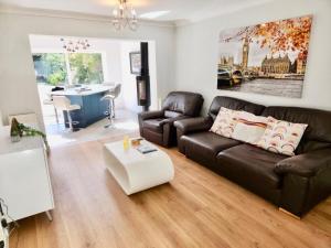 a living room with a leather couch and a coffee table at 4Bedroom Modern Bicester Villa, WIFI, Parking, Garden, Minutes walk to Bicester Village in Bicester +44 photos
