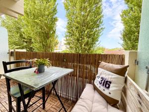 a small patio with a table and a couch at L'Estival, Royan in Royan