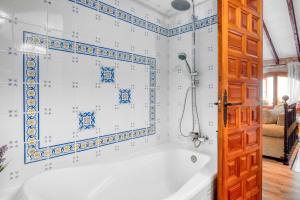 a bath tub in a bathroom with blue and white tiles at Casa Trinidad in Denia +18 photos