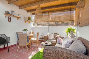 a living room with rattan furniture and a table at Casa Trinidad in Denia