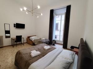 a bedroom with two beds and a couch and a window at Verdi Central Rooms in Florence