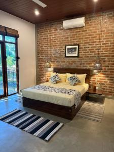 a bedroom with a bed and a brick wall at Turtle Pond Wilpattu in Wilpattu