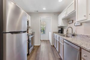a kitchen with white cabinets and a stainless steel refrigerator at Hillside Cottage in The Vineyards Resort in Branson