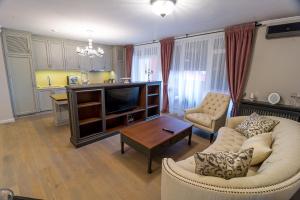 uma sala de estar com um sofá e uma televisão em Apartament Alex em Arad