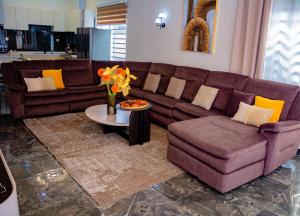 a living room with a brown couch and a table at Résidence LH in Brazzaville