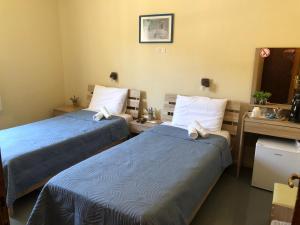 A bed or beds in a room at Platanos Rooms