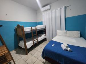 a bedroom with two bunk beds and a blue wall at Mini Hostel no centro de Tutoia in Tutóia