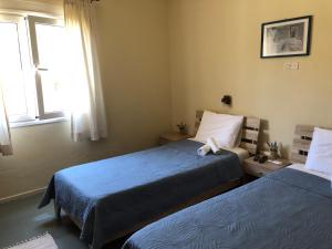 A bed or beds in a room at Platanos Rooms