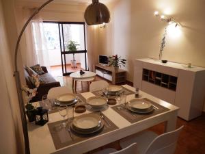 una sala de estar con una mesa con platos y vasos. en Apartment Amalia, en Albufeira