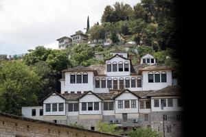 a large white building on top of a hill at Stitch&Stone Suites in Gjirokastër