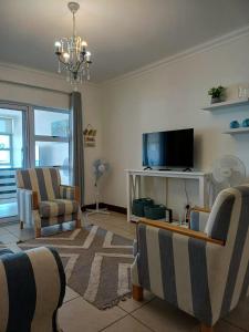 a living room with two chairs and a television at Vista Bonita 29 in Mossel Bay