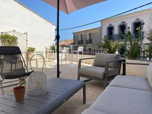 a patio with chairs and a table and an umbrella at La Hugotine in Marseillan