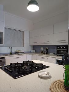 a kitchen with white cabinets and a stove top oven at Vista Bonita 29 in Mossel Bay +7 photos