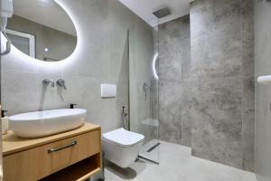 een badkamer met een wastafel, een toilet en een spiegel bij Vila Naço Ksamil in Ksamil +53 foto's