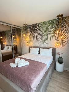 ein Schlafzimmer mit einem großen Bett, auf dem Handtücher liegen in der Unterkunft COZY Aparthotel - Luxury Studios # Brasov in Braşov