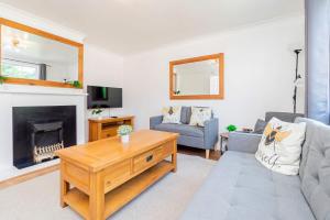 a living room with a couch and a fireplace at Beautiful 3 Bedroom Home with Parking & Garden in Colchester