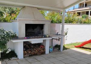 an outdoor pizza oven in a patio with a table at Villa with Pool and Mesmerizing Sea View in Fažana