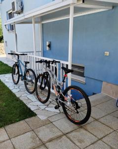 two bikes are parked next to a blue building at Villa with Pool and Mesmerizing Sea View in Fažana