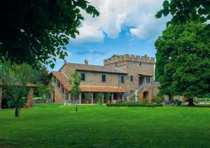 a large brick house with a green yard at Dependance Torretta Pucci in Civitella dʼAgliano