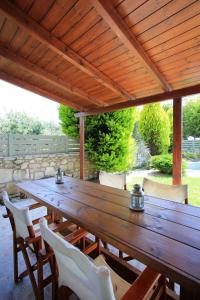 a wooden table and chairs under a wooden pergola at Katerinas Villa in Gálipe
