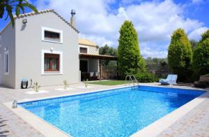 a villa with a swimming pool in front of a house at Katerinas Villa in Gálipe