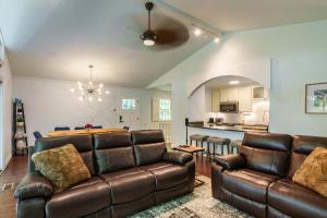 Una sala de estar con un sofá y una cocina. en Lake Lanier Lodge - Dock Views & Fire Pit, en Cumming