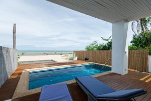 a swimming pool on a deck next to the beach at The HideAway Beach Villas - Kuiburi,Thailand in Prachuap Khiri Khan