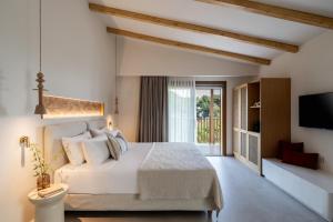 a bedroom with a white bed and a television at Dome Island in Troulos +99 photos