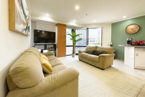 ein großes Wohnzimmer mit Couch und Tisch in der Unterkunft Two bedrooms Condo with Skytower View in Auckland