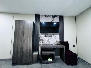 uma sala com uma mesa e uma TV na parede em Lofty Hotel em Ulaanbaatar