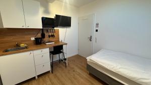 a bedroom with a bed and a desk with a sink at Böhl Station 1 Zimmer-Wohnungen in Böhl-Iggelheim