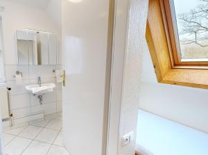 a bathroom with a sink and a window at Reiterpension Marlie in Scharbeutz