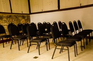 a row of black chairs in a room at Araújo Bazilio Pousada Tiradentes in Tiradentes