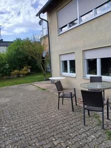 a patio with a table and chairs in front of a building at Gemütliche 2-Zimmer-Wohnung mit Top-Anbindung in Crailsheim