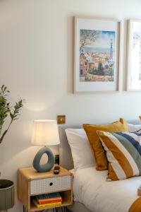 a living room with a bed and a table with a lamp at Large 4BR Contractor-Friendly House - Sleeps 10 - Free parking - North London in Enfield