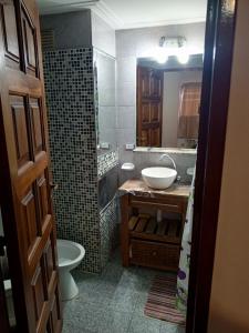 ein Badezimmer mit Waschbecken, Toilette und Spiegel in der Unterkunft Leo IV salta 636 4F in San Fernando del Valle de Catamarca
