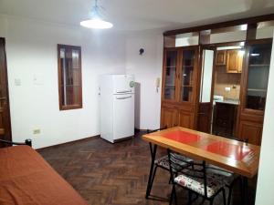 eine Küche mit einem Tisch und einem weißen Kühlschrank in der Unterkunft Leo IV salta 636 4F in San Fernando del Valle de Catamarca