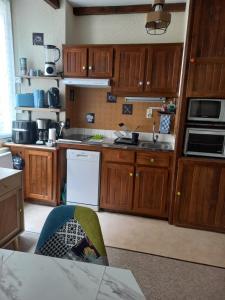 a kitchen with wooden cabinets and a counter top at Appartement Zen in Eaux-Bonnes