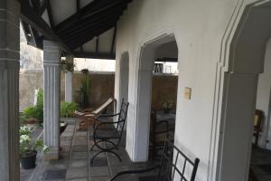 a patio with chairs and a table in a house at Mahagedara in Galle