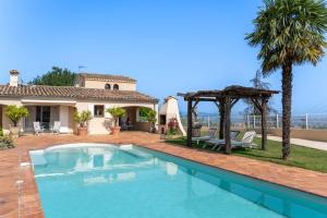 a villa with a swimming pool in front of a house at Villa Lazuel, piscine privée chauffée, vue panoramique et jardin clos in Aubenas