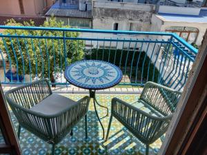 un balcon avec une table, deux chaises et un parasol dans l'établissement Nellerika Sorrento - Ametista Holidayhome, à Sorrente
