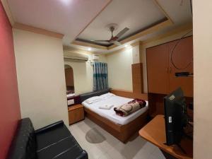 a small room with a bed and a chair at Starline Hotel in Agartala