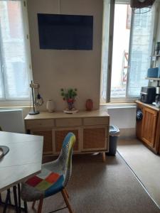 a living room with a table and chairs and windows at Appartement Zen in Eaux-Bonnes +2 photos