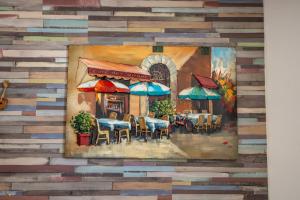 un dipinto di un ristorante con tavoli e ombrelloni di L'Orphie - 50m plage - confort - Baignoire a Berck-sur-Mer