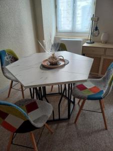 a white table with chairs and a plate on it at Appartement Zen in Eaux-Bonnes