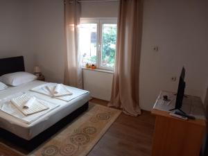 a small bedroom with a bed and a window at Apartman Eldar in Mostar +12 photos