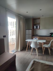 a kitchen with a table and a table and chairs at Camping Relax Sol in Torredembarra