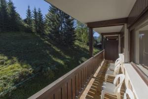 a porch with white chairs and a large window at Résidence Le Relax - Megève Centre in Megève